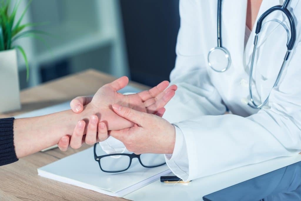 Female patient at orthopedic doctor medical exam for wrist injury