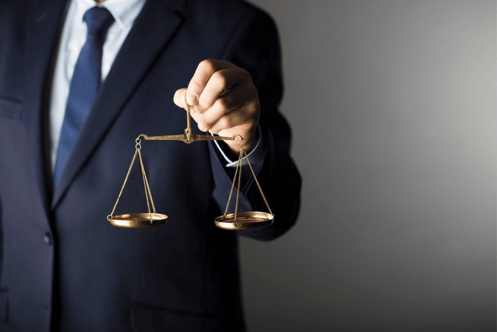 A businessman holding a scale of justice.