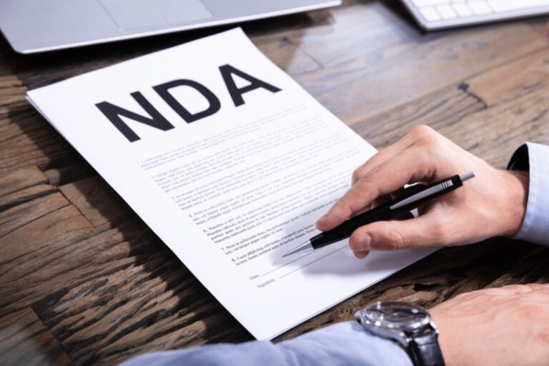 A person signing a document with the word nda.