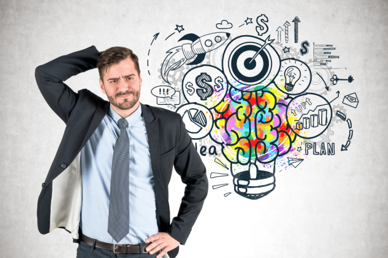A businessman standing in front of a light bulb with ideas drawn on it.