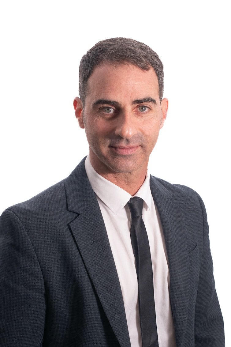 גבר בחליפה ועניבה מצטלם.