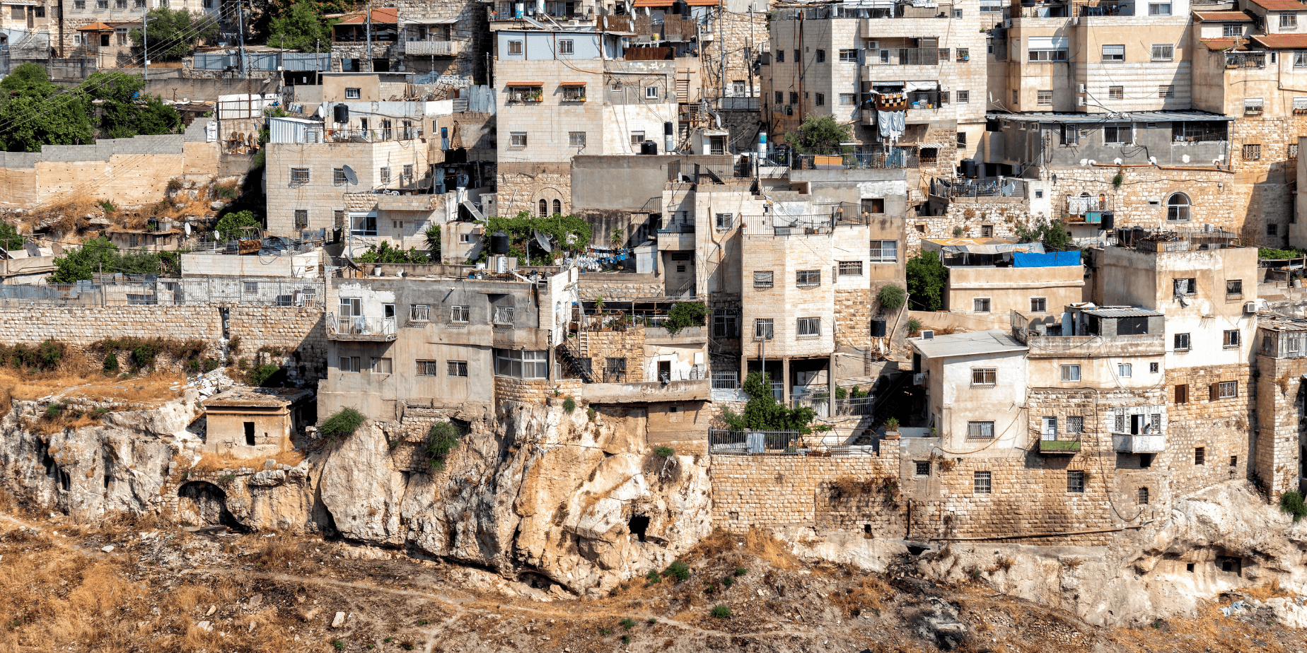 בנייני מגורים עמוסים בצפיפות הניצבים על צלע גבעה סלעית.