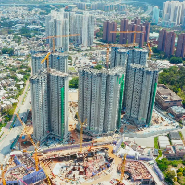 מבט אווירי של אתר בנייה עם מספר רב של בניינים רבי קומות בפיתוח באזור עירוני.