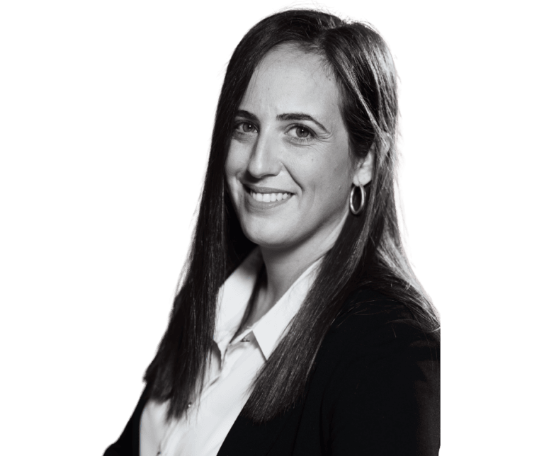 דיוקן שחור ולבן של אדם עם שיער ארוך וחלק. הם מחייכים ולובשים חולצת צווארון לבנה מתחת לבלייזר כהה. הרקע לבן רגיל, והאדם מופנה מעט לשמאלו.