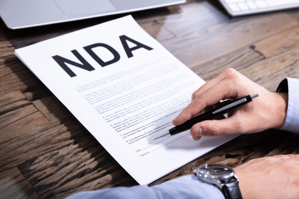 Signing a non-disclosure agreement document on a desk
